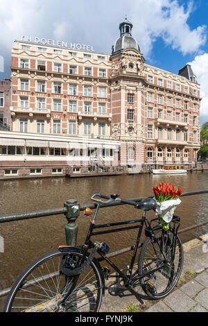 NH Doelen Hotel, bicycle with tulips, Amsterdam, Netherlands Stock Photo
