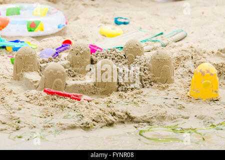 Sand castle circle and toys on the river bank Stock Photo