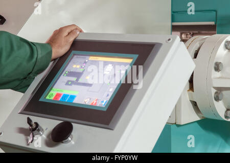 man operating factory machinery Stock Photo