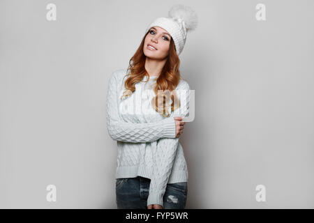 Portrait of beautiful redhead woman in white sweater and hat Stock Photo