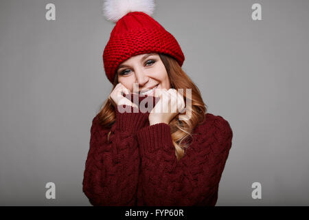 Portrait of beautiful redhead woman in red sweater and hat Stock Photo