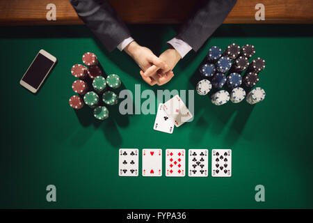 Elegant male poker player's hands with chips stacks, cards and smartphone, top view Stock Photo