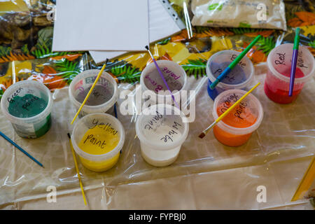 Paint pots laid out for craft with paintbrushes Stock Photo