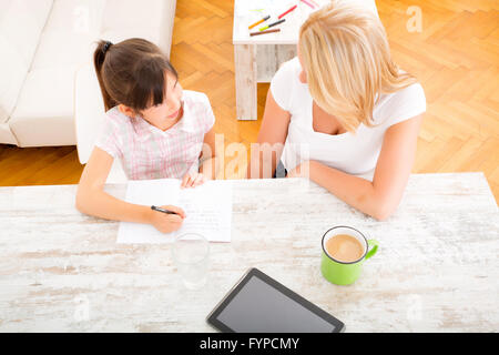 Mother helping her daughter with the homework Stock Photo