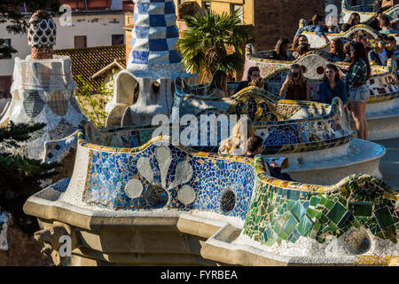 Tourists enjoying the multicolored serpentine bench at Park Guell, Barcelona, Catalonia, Spain Stock Photo