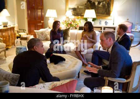 U.S President Barack Obama talks with Prince William, the Duke of Cambridge while Kate Middleton, Duchess of Cambridge and Prince Harry of Wales, speak with First Lady Michelle Obama at Kensington Palace April 22, 2016 in London, United Kingdom. Stock Photo