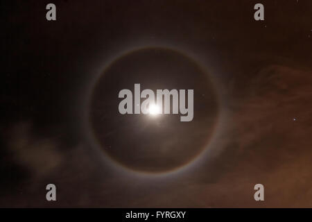 '22 Degree Halo' Ice crystals refracting light forming a circle around the moon (or sun). Stock Photo