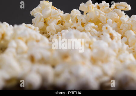 Closeup pile of white fluffy popcorn seen from low angle with grey background Stock Photo