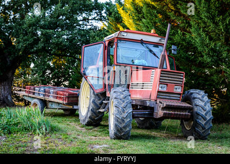 Old red tractor with trailer Stock Photo