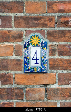 Number 4 sun house plaque on a red brick wall Stock Photo