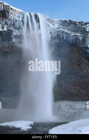 Seljalandsfoss, 66 m high waterfall situated on the river Seljalandsá in winter, Rangárþing eystra, Iceland Stock Photo