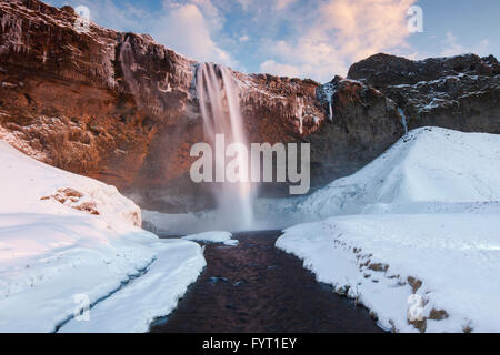 Seljalandsfoss, 66 m high waterfall situated on the river Seljalandsá in winter, Rangárþing eystra, Iceland Stock Photo