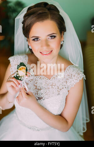 Close-up portreit of beautiful bride in fashion veil with buttonhole Stock Photo