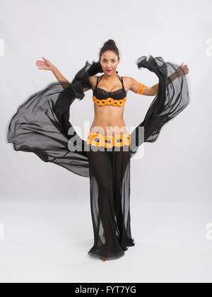 Young girl mulatto dancing in a long black dress candid Stock Photo