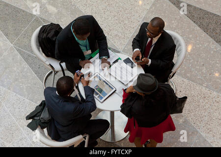 African businessmen in a business meeting working at a small table - USA Stock Photo