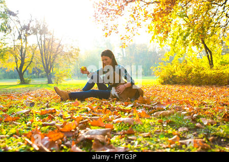 Beautiful young woman playing with her Dog in the forest Stock Photo