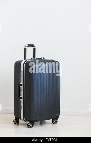Large family polycarbonate luggage on white wooden background. Stock Photo