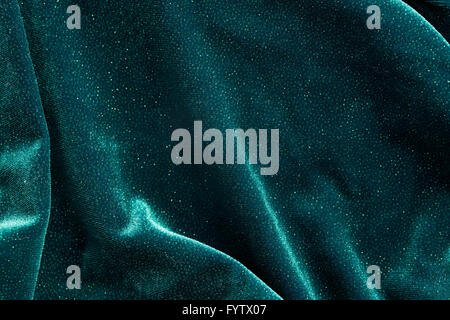 An abstract shot of wavy green fabric of a dress with glitter on it. Stock Photo