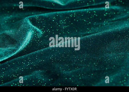An abstract shot of wavy green fabric of a dress with glitter on it. Stock Photo