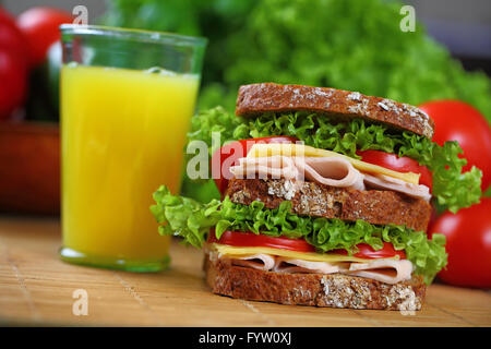 Double sandwich with brown bread, ham, lettuce, tomato, cheese. Stock Photo