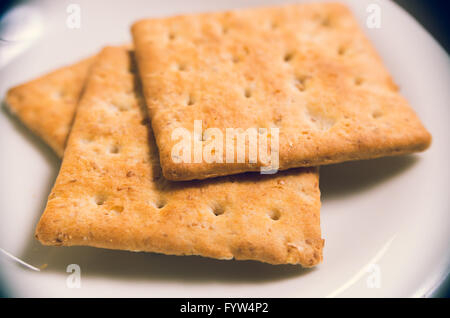 Closeup of three grain buiscuits neatly placed on a white plate from elevated side angle Stock Photo