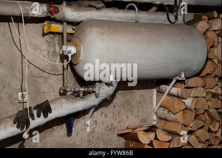Boiler in cellar interior, dark underground basement room under country home building, house heating system in the fireplace Stock Photo