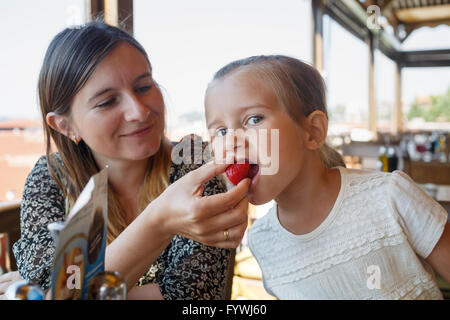 Mom feeds her daughter Stock Photo