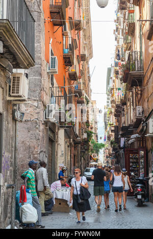 Naples, Italy - August 9, 2015: Narrow street of Naples, ordinary people and tourists walk on old city Stock Photo
