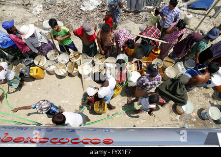 (160428) -- YANGON, April 28, 2016 (Xinhua) -- People line up with buckets to collect drinking water from donors at Dala Township on the outskirts of Yangon, Myanmar, April 28, 2016. Myanmar residents in Dala Township face with water shortage during the dry season in April and May every year. A powerful El Nino affecting Myanmar this year will be the strongest in five centuries and is expected to bring a record high temperature in the country, said a noted and retired Myanmar meteorology and hydrology expert. The public are being advised to transport water and tube wells to rural areas where i Stock Photo