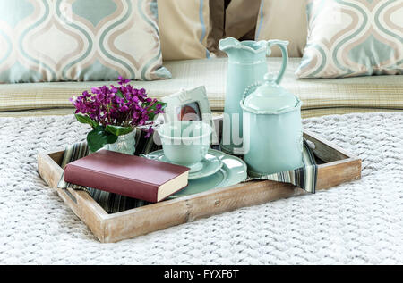 Decorative tray with book,tea set and flower on the bed Stock Photo