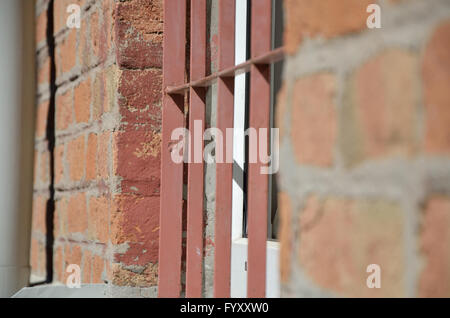 Window in brick wall protected with iron bars Stock Photo