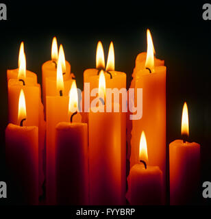 A bunch of lit candles, inside. Stock Photo