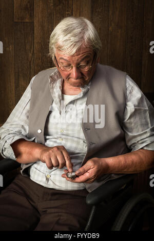 Elderly man checking the time on his antique pocket watch Stock Photo