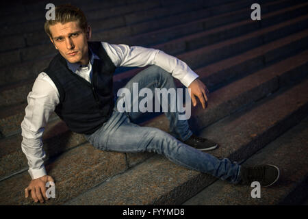 Handsome guy sitting on stairs. Stock Photo