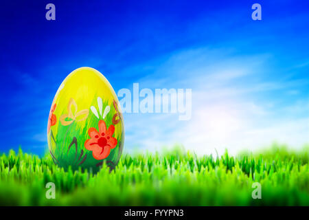 Hand painted Easter egg on grass. Floral Stock Photo
