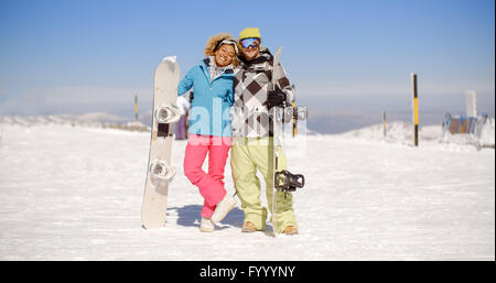 Happy young couple posing with their snowboards Stock Photo