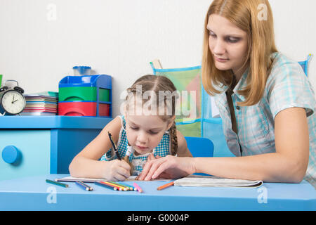Girl draws interest on a cliche, a young girl helps her Stock Photo