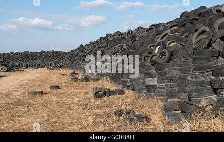Old  used rubber tires  piled  in a recycling yard waiting to be  shredded and  remanufactured into usable  products Stock Photo