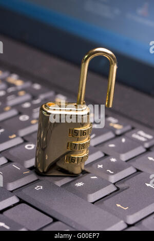 a golden padlock on a black notebook keyboard Stock Photo