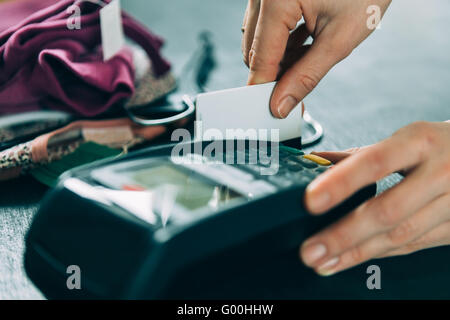 hand swiping credit card in store Stock Photo