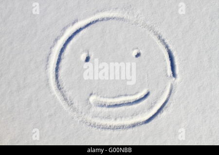 Smiley face drawn on snow background Stock Photo