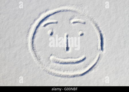 Smiley face drawn on snow background Stock Photo