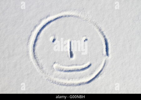 Smiley face drawn on snow background Stock Photo