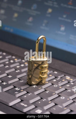 a golden padlock on a black notebook keyboard Stock Photo
