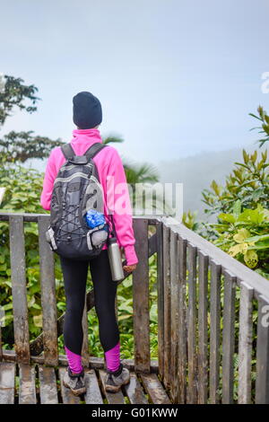 mountaineer girl looking from a wooden terace viewpoint Stock Photo