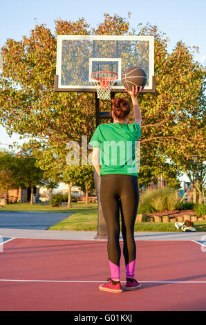 Young woman shooting at the basket. Basketball player Stock Photo