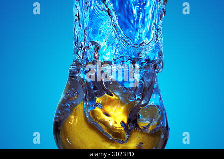 close-up of splash of blue fluid in a glass with lemon Stock Photo