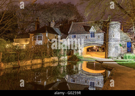 The 15th century Pulls Ferry at night, the water gate for Norwich Cathedral, on the River Wensum, Norwich, Norfolk, England, UK Stock Photo
