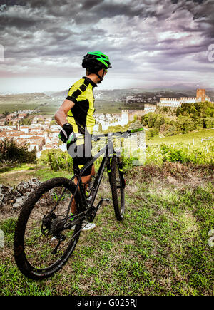 Cyclist admires from the hill the Soave castle views. Stock Photo