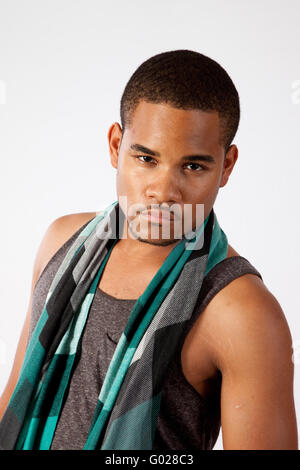 Young man with a scarf around his neck, looking thoughtfully at the camera Stock Photo